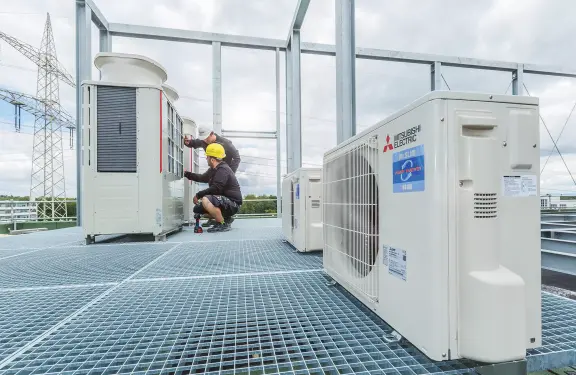 Mitsubishi Electric City Multi Anlage auf Dach Fachhandwerker an einer City Multi Anlage auf einem Dach
